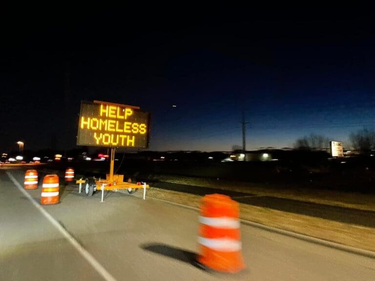 Road Sign That Says "Help Homeless Youth"