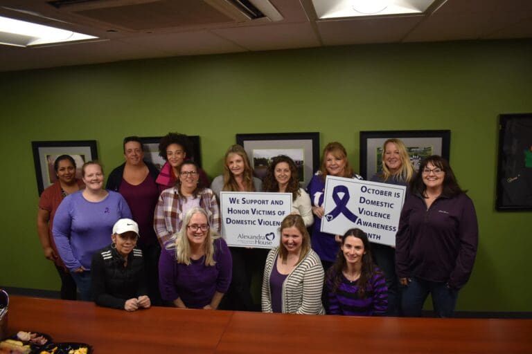Walters Employees Hold Up An "October Is Domestic Violence Awareness Month" Sign. And Another Sign That Says "We Support And Honor Victims Of Domestic Violence"