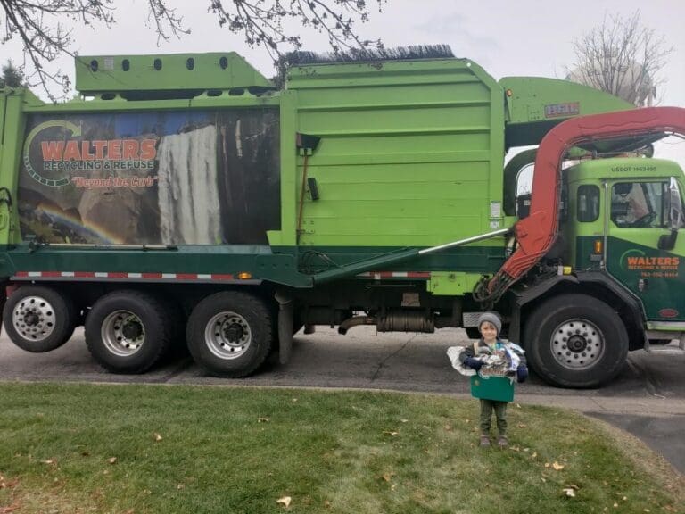 Young Child Holding Items In Front Of Walters Truck