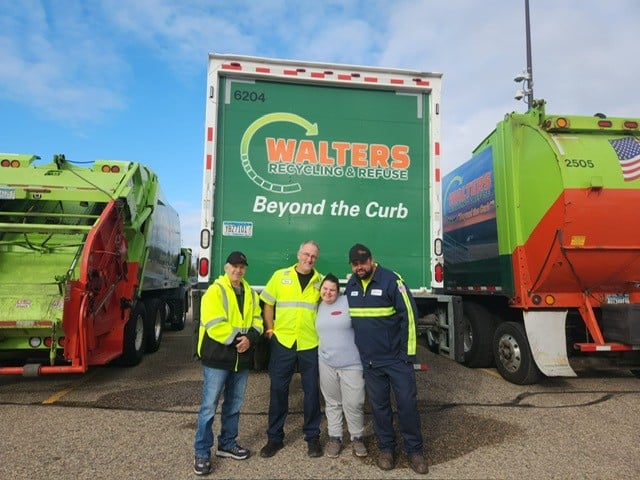 Four Walters Employees Take A Picture In Front Of Trucks