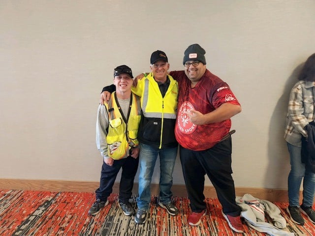 Three Volunteers Pose For A Photo
