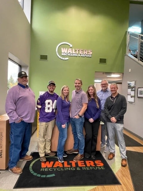 Seven People From Nonprofit Event Pose In Front Lobby