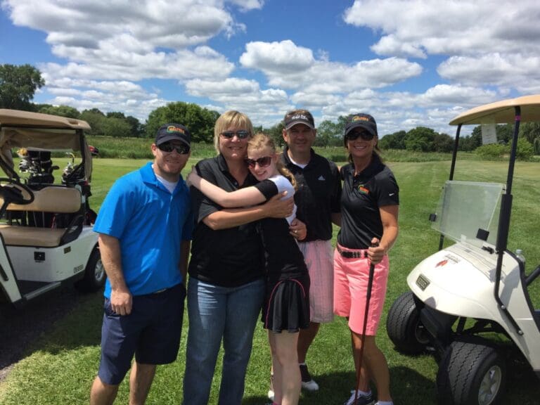 Five People Taking Picture Together At Golf Course
